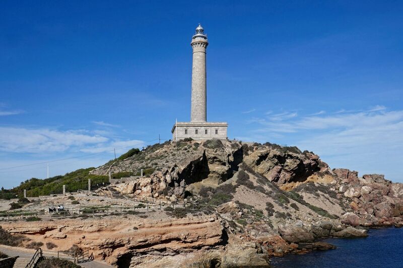 DC 24-0764-031.jpg :: Cabo de Palos, La Manga, Spain: The lighthouse of Cabo de Palos is located on an approximately 600 meters-wide small peninsula in the municipality of Cartagena. Back in its time, there was a watchtower where the lighthouse is currently located. The simple structure is defined by its surveillance function as well as the lighthouse-keepers school which was housed in its base. The construction started in 1863 and the lighthouse was first lit on the 31st January, 1865. The building rises 30 meters above sea level, according to Leonardo de Tejada's project. Ashlar stones brought in from a quarry located in the town of Sabinar were used as building material. It has a prism-shaped base of 20 meters on each side and 14 meters high with rusticated edges. In the middle of the base, above an octagonal shaped pedestal rises the 54 meters high tower. It adopts the form of a Tuscan order column, and its capital consists of various corbels that hold up a circular cornice with an openwork parapet in a shape of a balustrade. Above, there is a cylindrical tower where the lantern is built in. Nowadays, it has a beacon with a range of 24 miles. Photo taken 06/12/2024