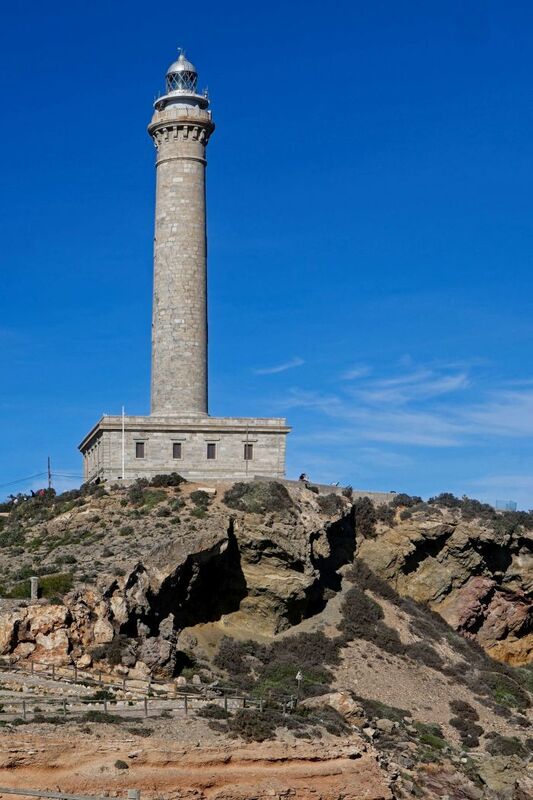 DC 24-0764-036.jpg :: Cabo de Palos, La Manga, Spain: The lighthouse of Cabo de Palos is located on an approximately 600 meters-wide small peninsula in the municipality of Cartagena. Back in its time, there was a watchtower where the lighthouse is currently located. The simple structure is defined by its surveillance function as well as the lighthouse-keepers school which was housed in its base. The construction started in 1863 and the lighthouse was first lit on the 31st January, 1865. The building rises 30 meters above sea level, according to Leonardo de Tejada's project. Ashlar stones brought in from a quarry located in the town of Sabinar were used as building material. It has a prism-shaped base of 20 meters on each side and 14 meters high with rusticated edges. In the middle of the base, above an octagonal shaped pedestal rises the 54 meters high tower. It adopts the form of a Tuscan order column, and its capital consists of various corbels that hold up a circular cornice with an openwork parapet in a shape of a balustrade. Above, there is a cylindrical tower where the lantern is built in. Nowadays, it has a beacon with a range of 24 miles. Photo taken 06/12/2024