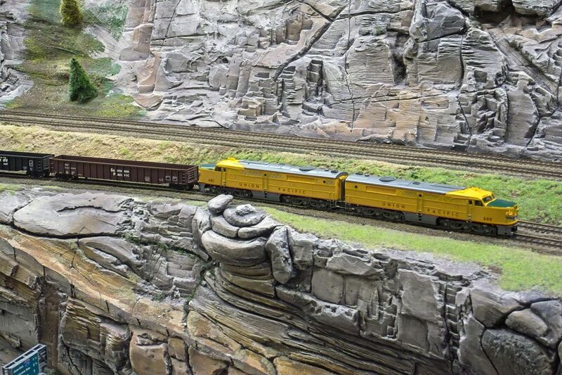 DC 25-0767-065.jpg :: Miniatur Wunderland Hamburg, Germany: The Miniatur Wunderland is, according to Guinness World Records, the largest model railway system in the world. It is located at the historic Speicherstadt in Hamburg and is one of the most popular and most visited sights in Germany. The exhibition includes around 1,230 digitally controlled trains with more than 12,000 wagons. The Wonderland is also designed with around 4,300 houses and bridges, more than 10,000 vehicles – of which around 350 drive independently on the installation – 47 airplanes and around 290,000 figures. The system features a recurring day-night lighting cycle and almost 500,000 built-in LED lights. Of the 7,000 m2 (75,347 sq ft) of floorspace, the models occupies 1,545 m2 (16,630 sq ft). P.s. Part of the USA section of the exhibition. Railway in the west coast of America. Photo taken 20/01/2025