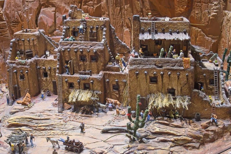DC 25-0767-083.jpg :: Miniatur Wunderland Hamburg, Germany: The Miniatur Wunderland is, according to Guinness World Records, the largest model railway system in the world. It is located at the historic Speicherstadt in Hamburg and is one of the most popular and most visited sights in Germany. The exhibition includes around 1,230 digitally controlled trains with more than 12,000 wagons. The Wonderland is also designed with around 4,300 houses and bridges, more than 10,000 vehicles – of which around 350 drive independently on the installation – 47 airplanes and around 290,000 figures. The system features a recurring day-night lighting cycle and almost 500,000 built-in LED lights. Of the 7,000 m2 (75,347 sq ft) of floorspace, the models occupy 1,545 m2 (16,630 sq ft). P.s. Part of the USA section of the exhibition. A Pueblo Settlement in Arizona. Showing the people their traditional clay huts, some of which are only accessible by ladders. Photo taken 20/01/2025