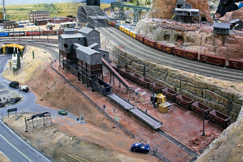 DC 25-0767-088.jpg :: Miniatur Wunderland Hamburg, Germany: The Miniatur Wunderland is, according to Guinness World Records, the largest model railway system in the world. It is located at the historic Speicherstadt in Hamburg and is one of the most popular and most visited sights in Germany. The exhibition includes around 1,230 digitally controlled trains with more than 12,000 wagons. The Wonderland is also designed with around 4,300 houses and bridges, more than 10,000 vehicles – of which around 350 drive independently on the installation – 47 airplanes and around 290,000 figures. The system features a recurring day-night lighting cycle and almost 500,000 built-in LED lights. Of the 7,000 m2 (75,347 sq ft) of floorspace, the models occupy 1,545 m2 (16,630 sq ft). P.s. Part of the USA section of the exhibition. An Ore loading facility. In this loading facility the neighbouring mine is loaded on to trains. Photo taken 20/01/2025