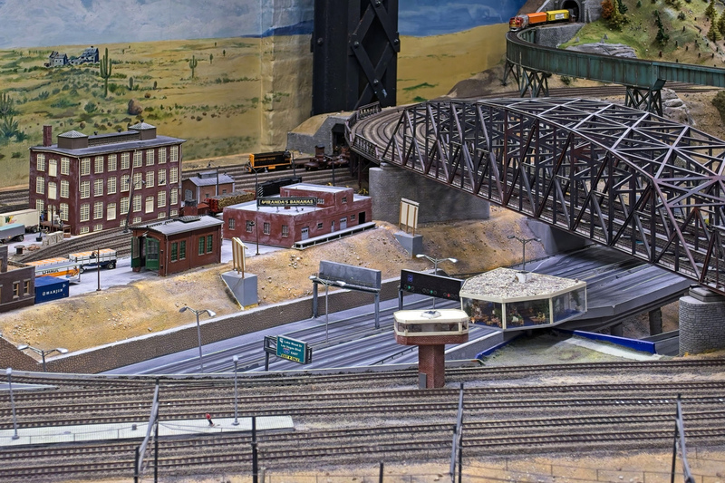 DC 25-0767-103.jpg :: Miniatur Wunderland Hamburg, Germany: The Miniatur Wunderland is, according to Guinness World Records, the largest model railway system in the world. It is located at the historic Speicherstadt in Hamburg and is one of the most popular and most visited sights in Germany. The exhibition includes around 1,230 digitally controlled trains with more than 12,000 wagons. The Wonderland is also designed with around 4,300 houses and bridges, more than 10,000 vehicles – of which around 350 drive independently on the installation – 47 airplanes and around 290,000 figures. The system features a recurring day-night lighting cycle and almost 500,000 built-in LED lights. Of the 7,000 m2 (75,347 sq ft) of floorspace, the models occupy 1,545 m2 (16,630 sq ft). P.s. Part of the USA section of the exhibition. Photo taken 20/01/2025