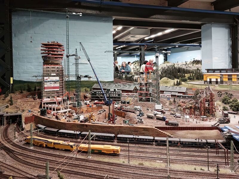 DC 25-0767-167.jpg :: Miniatur Wunderland Hamburg, Germany: The Miniatur Wunderland is, according to Guinness World Records, the largest model railway system in the world. It is located at the historic Speicherstadt in Hamburg and is one of the most popular and most visited sights in Germany. The exhibition includes around 1,230 digitally controlled trains with more than 12,000 wagons. The Wonderland is also designed with around 4,300 houses and bridges, more than 10,000 vehicles – of which around 350 drive independently on the installation – 47 airplanes and around 290,000 figures. The system features a recurring day-night lighting cycle and almost 500,000 built-in LED lights. Of the 7,000 m2 (75,347 sq ft) of floorspace, the models occupy 1,545 m2 (16,630 sq ft). P.s. Part of the Germany section of the exhibition. P.s. High-rise construction site in the Hamburg section. Photo taken 20/01/2025.