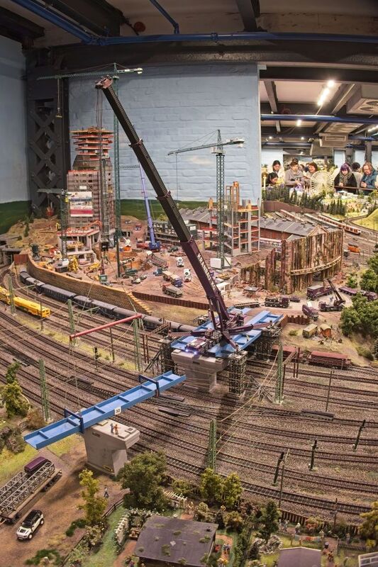 DC 25-0767-170.jpg :: Miniatur Wunderland Hamburg, Germany: The Miniatur Wunderland is, according to Guinness World Records, the largest model railway system in the world. It is located at the historic Speicherstadt in Hamburg and is one of the most popular and most visited sights in Germany. The exhibition includes around 1,230 digitally controlled trains with more than 12,000 wagons. The Wonderland is also designed with around 4,300 houses and bridges, more than 10,000 vehicles – of which around 350 drive independently on the installation – 47 airplanes and around 290,000 figures. The system features a recurring day-night lighting cycle and almost 500,000 built-in LED lights. Of the 7,000 m2 (75,347 sq ft) of floorspace, the models occupy 1,545 m2 (16,630 sq ft). P.s. Part of the Germany section of the exhibition. P.s. High-rise construction site in the Hamburg section. Photo taken 20/01/2025.