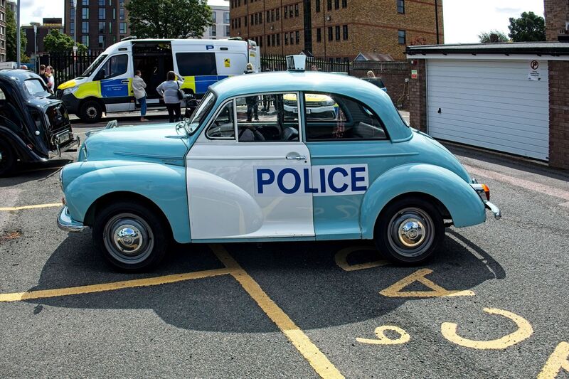 DC 25-0777-014.jpg :: Marlow House, Sidcup, Historic Police Cars Display: A Met Police 1970 Morris Minor 1000 Panda Car. Part of the Metropolitan Police Historic Vehicle Collection. This vehicle was used as a supervisor’s car to check on the beat officers and respond to calls. The aerial on the offside rear wing is an indicator that it wasn't an ordinary beat car. The white stripe across the roof that linked both doors is now missing on the later versions of Met Police Pandas, in order to reduce cost. Photo taken 08-06-2025