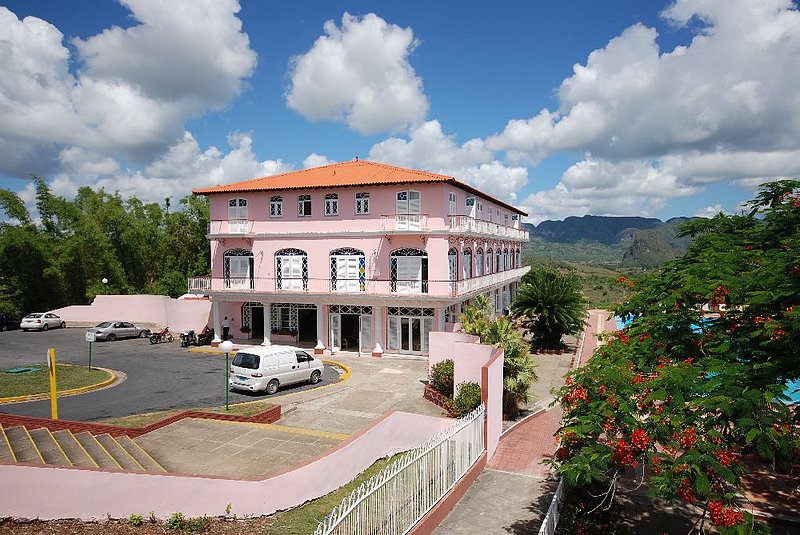 DC 11-0255-003.jpg :: Viñales Valley, Cuba:- With its unbeatable position overlooking the Viñales valley, Los Jazmines is one of the most renowned hotels in Cuba. The Los Jazmines main building is graced with tilework, wrought-iron balconies, and stained-glass mediopuntos (half-moon windows), all in elegant traditional fashion. 27/05/2011

