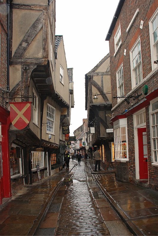 DC 12-0277-006.jpg :: Shambles, York: The Shambles (official name Shambles) is an old street in York, England, with overhanging timber-framed buildings, some dating back as far as the fourteenth century. It was once known as The Great Flesh Shambles, probably from the Anglo-Saxon Fleshammels (literally 'flesh-shelves'), the word for the shelves that butchers used to display their meat. As recently as 1872 there were twenty-five butchers' shops in the street but now there are none. 24/01/2012
