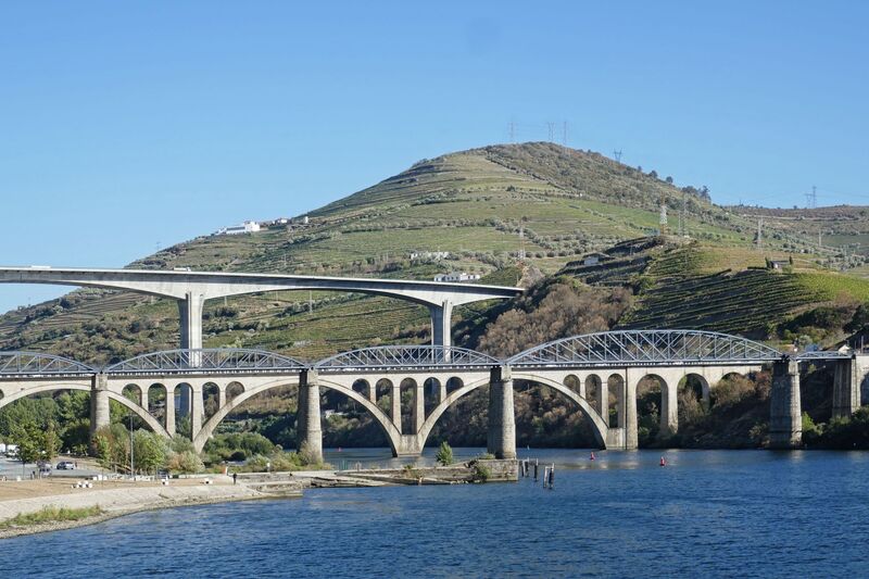 DC 22-0789-014.jpg :: Saga Douro River Cruise, Regua Lamego to Pinhao, River Douro: The Ponte Miguel Torga is a modern concrete viaduct carrying the A-24 highway across the Douro River near Peso da Régua, and is named after the renowned 20th-century Portuguese writer Miguel Torga. The 900-meter-long bridge features a continuous prestressed concrete box girder deck and a large 180-meter span over the river. Photo taken 30/08/2022.