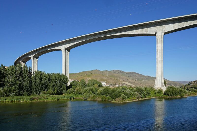 DC 22-0789-020.jpg :: Saga Douro River Cruise, Regua Lamego to Pinhao, River Douro: The Ponte Miguel Torga is a modern concrete viaduct carrying the A-24 highway across the Douro River near Peso da Régua, and is named after the renowned 20th-century Portuguese writer Miguel Torga. The 900-meter-long bridge features a continuous prestressed concrete box girder deck and a large 180-meter span over the river. Photo taken 30/08/2022.