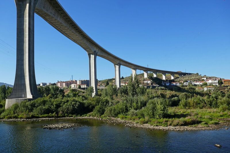 DC 22-0789-021.jpg :: Saga Douro River Cruise, Regua Lamego to Pinhao, River Douro: The Ponte Miguel Torga is a modern concrete viaduct carrying the A-24 highway across the Douro River near Peso da Régua, and is named after the renowned 20th-century Portuguese writer Miguel Torga. The 900-meter-long bridge features a continuous prestressed concrete box girder deck and a large 180-meter span over the river. Photo taken 30/08/2022.