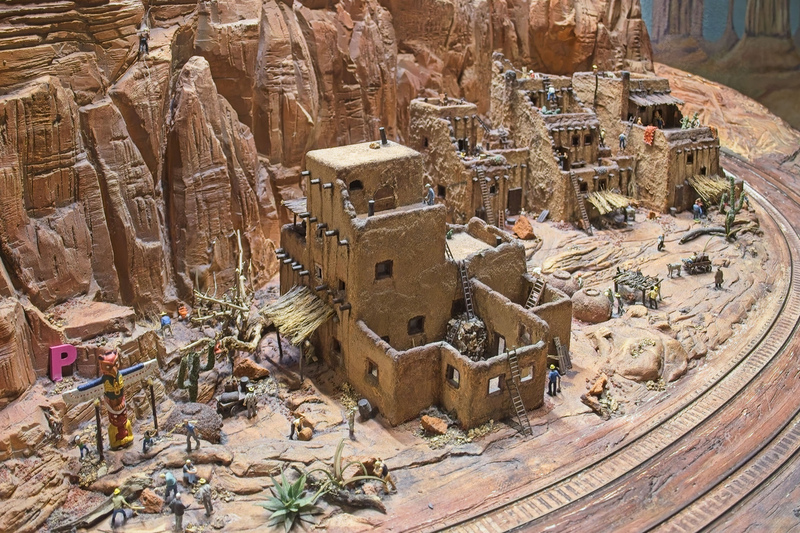 DC 25-0767-084.jpg :: Miniatur Wunderland Hamburg, Germany: The Miniatur Wunderland is, according to Guinness World Records, the largest model railway system in the world. It is located at the historic Speicherstadt in Hamburg and is one of the most popular and most visited sights in Germany. The exhibition includes around 1,230 digitally controlled trains with more than 12,000 wagons. The Wonderland is also designed with around 4,300 houses and bridges, more than 10,000 vehicles – of which around 350 drive independently on the installation – 47 airplanes and around 290,000 figures. The system features a recurring day-night lighting cycle and almost 500,000 built-in LED lights. Of the 7,000 m2 (75,347 sq ft) of floorspace, the models occupy 1,545 m2 (16,630 sq ft). P.s. Part of the USA section of the exhibition. A Pueblo Settlement in Arizona. Showing the people their traditional clay huts, some of which are only accessible by ladders. Photo taken 20/01/2025