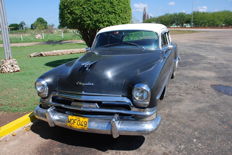 DC 11-0240-015.jpg :: 2011 - Cuban Classic Cars - 1954 Chrysler Windsor Deluxe outside resturante at La Aguada. These American dream cars are common all over Cuba. There is no suggestion that the car is in its original condition as these cars are kept running using all sorts or suitable spares and non original components. The chances are the engines are either Japanese or Russian. Reg. No. MDF 409 on a yellow Cuban plate. 29/05/2011  
