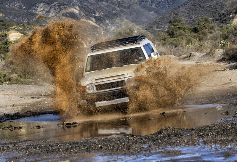A 4x4 Vehicle driving through a puddle splashing water.jpg :: A 4x4 vehicle  driving through puddle with water splashing Trabucco Canyon Ca