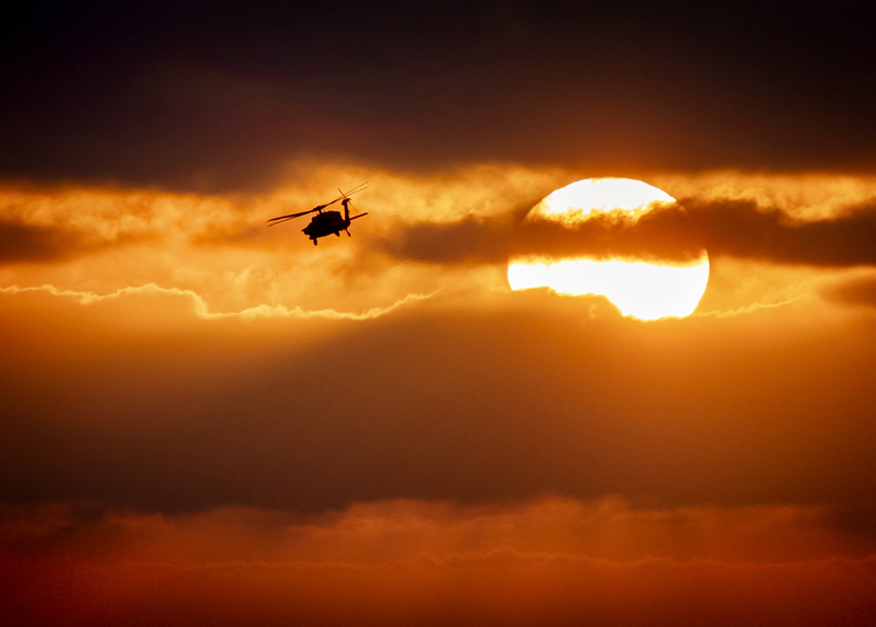 Blackhawk Helicopter at Sunset028B.jpg :: A helicopter banking left away from the sun during a cloudy sunset over the pacific ocean
