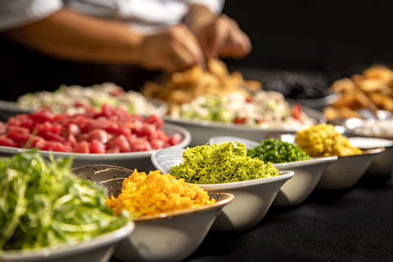 Chef preparing meal with multiple spices .jpg :: Rows of ingredients and spices in a bowl with chefs hands diffused in the background