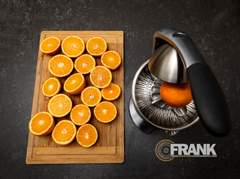 Orange juicer with sliced oranges on a cutting board 001ALOGO(1).jpg :: Orange juicer with sliced oranges on a cutting board