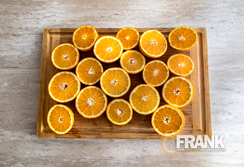 Overhead image of Orange slides on a cutting board  on w white granite surface 003LOGO(1).jpg :: Overhead image of Orange slides on a cutting board  on w white granite surface
