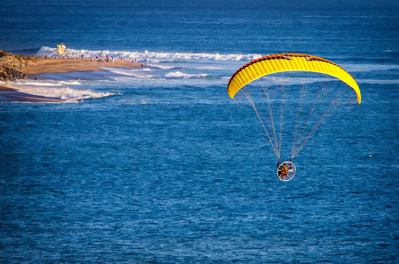 Parasailer headed toward penninsula 001A.jpg :: Image shot from slightly above a Paraglider at an altitude of  about 500 feet headed toward people on beach and lifeguard tower on finger of land located at San Clemente CA