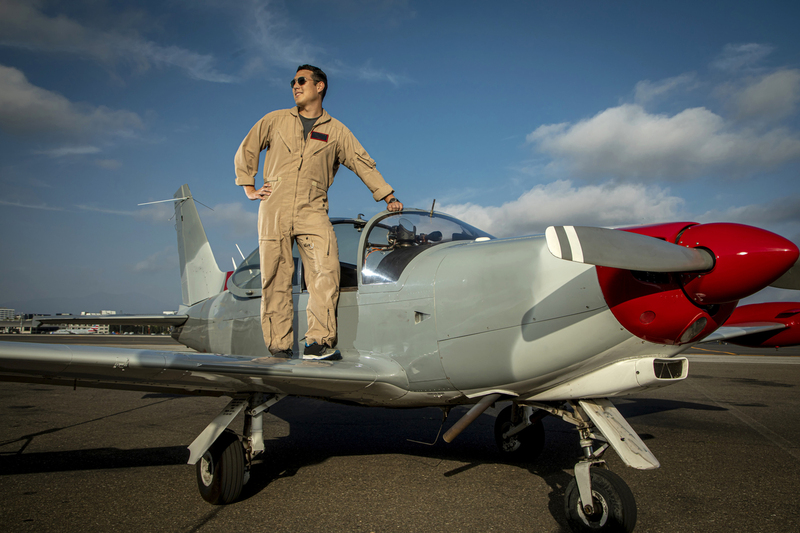 Pilot and fighter airplane wearing a jumpsuit 001A-1 .jpg :: Pilot standing on the wing of a and fighter airplane wearing a jumpsuit against a blue sky