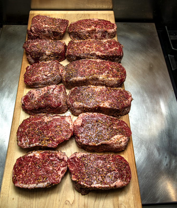 Twelve Seasoned Steaks on a cutting board  002(1).jpg :: Twelve Seasoned Steaks on a cutting board in an industrial kitchen