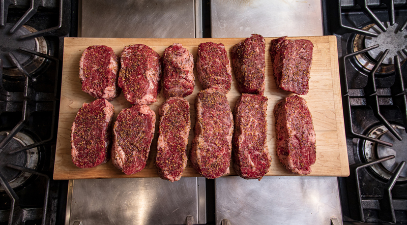 Twelve Seasoned Steaks on a cutting board  014(1).jpg :: Twelve Seasoned Steaks on a cutting board in an industrial kitchen