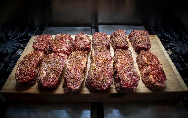 Twelve Seasoned Steaks on a cutting board  021(1).jpg :: Twelve Seasoned Steaks on a cutting board in an industrial kitchen
