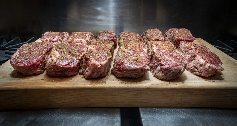 Twelve Seasoned Steaks on a cutting board  030(1).jpg :: Twelve Seasoned Steaks on a cutting board in an industrial kitchen