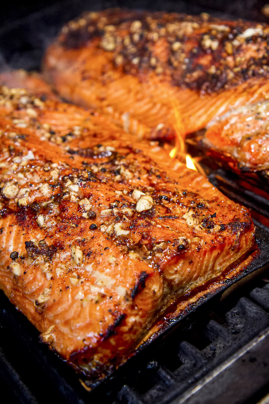 close up of Salmon with garlic clove rub on cedar planks cooking on BBQ 001.jpg :: Salmon with garlic glaze on bar-b-que grill with salmon cooking in background