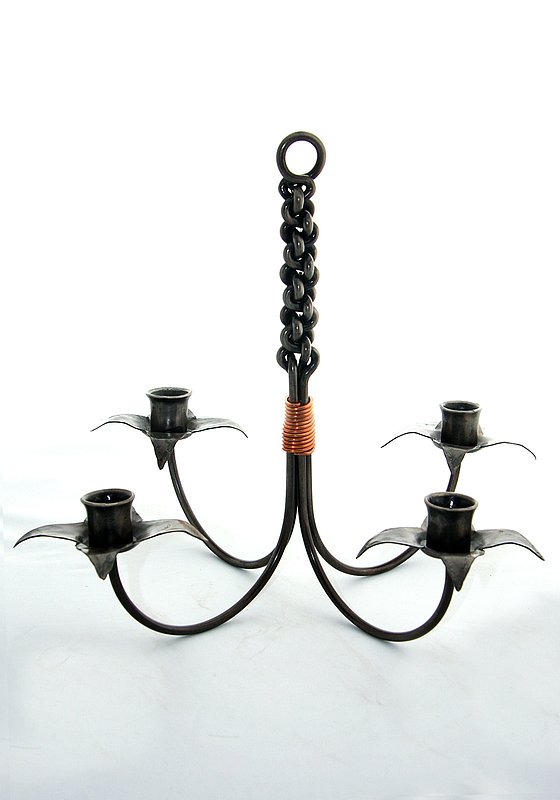 Candelabra.jpg :: $75 - This beautifully forged four-light candelabra can be displayed hanging from a ceiling or hook or standing as a table centerpiece. The stem of the candelabra is made from weaving the four stems that hold the candles and it's set off with a copper wire binding at its center. The candelabra is approx 10\