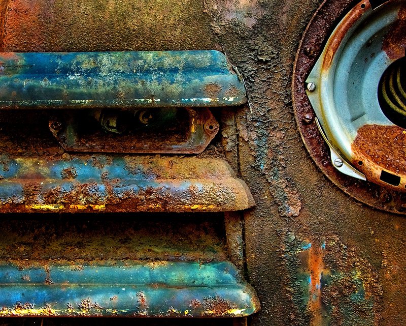 Chevy Grill Abstract-1.jpg :: The old Chevy offered several possibilities for shooting the grill. I like this view because the straight grill lines lead left to right (just like we read) and point directly at the round lines of the headlight. The light provided great contrast and texture to the paint and rust. This was shot in RAW and handled lots of sharpening.