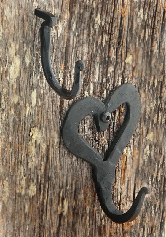 Hooks.jpg :: $3.00 & $6.00 - You always need a hook! The drive hook ($3.00) is purely functional: drive it into a wall or post and it's ready for hanging. The heart hook ($6.00) works just as hard, but it does it with a softer touch and adds a nice decorative touch. Screw it into a wall or post, or mount several on that favorite piece of wood to make a custom coat rack. Both pieces have hammer marks on their surface and the \