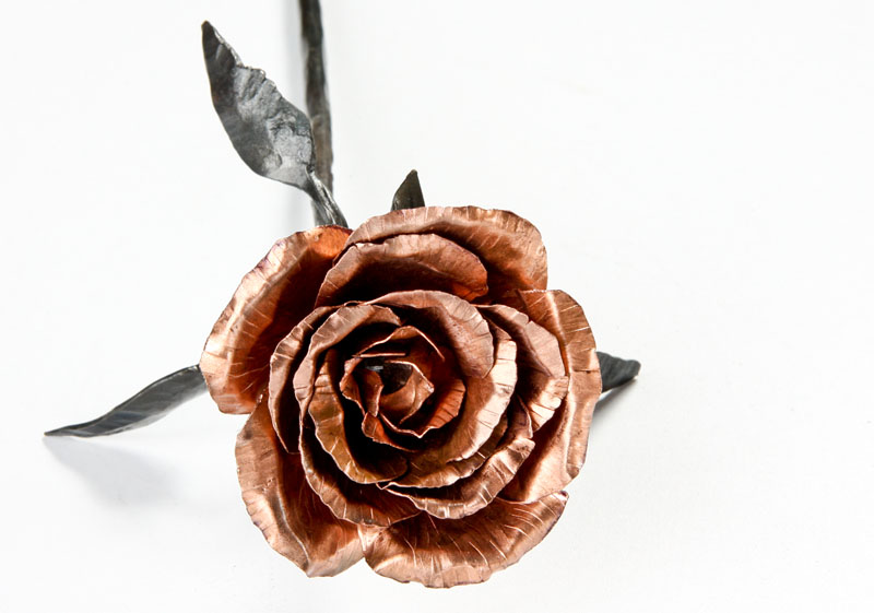 Rose-Copper_004.jpg :: The copper petals of this rose join a black steel stem that is approx 10 inches long. There are three leaves that are each etched with veining, and each copper petal is individually hammered and folded to resemble a flowering rose.
