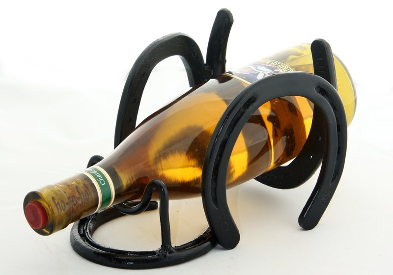 Wine Rack - Single.jpg :: $35.00 - Whether you are an equestrian who loves wine, or an oenophile who enjoys horses, this wine rack is made for you. We'll provide the shoes to make the rack, or if you've got special memories attached to your old horseshoes we can work with those, too. It takes four shoes to make one rack. Bottle of wine not included. This piece is approx 6\