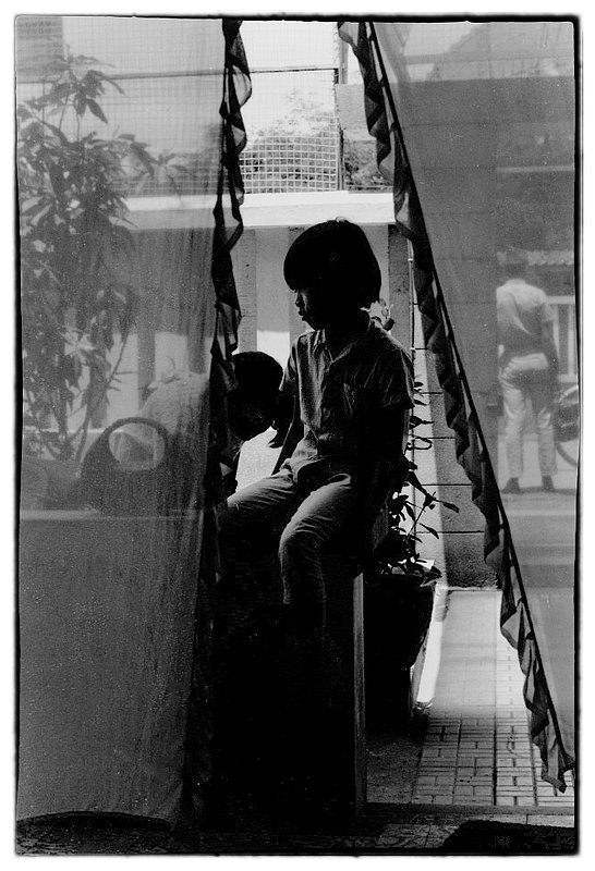 Child and Lace.jpg :: Passing by what seemed to be an upper class section of Saigon, i spotted this young lady sitting in a lace covered doorway.