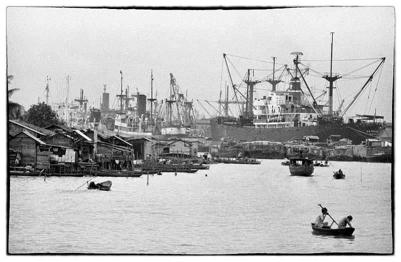 Port.jpg :: Saigon is always busy, especially along the Saigon River where a mixture of family boat house people live in concert with the activities of US Military, Civilian ships as well as small junk boats traversing the river constantly supporting Vietnamese commerce.