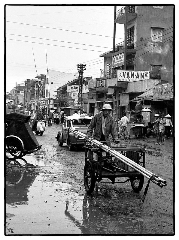 Rain or Shine.jpg :: Saigon street scene, rain or shine people go about their daily duties and needs of the day.