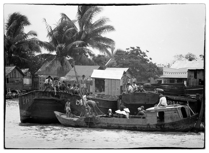 River and Family.jpg :: In Vietnam you never knew for sure who people really were. Were they friendly during the day and Viet Cong at night. In short the rivers accommodated Boat families all grouped together in what seemed to be a making a living for family atmosphere. Yet one never really knew.
