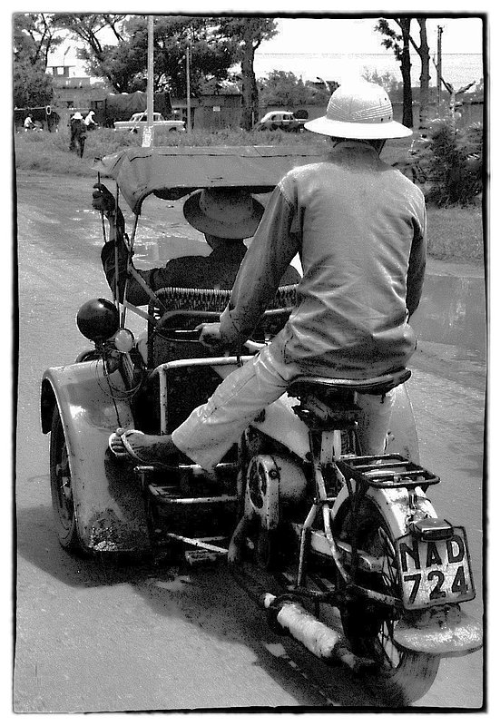 Taxi 724.jpg :: In Vietnam there are many types of transportation moving people from point A to point B. I was surprised to spot this Motorcycle that had been converted to a taxi. The Vietnamese are a very ingenious.