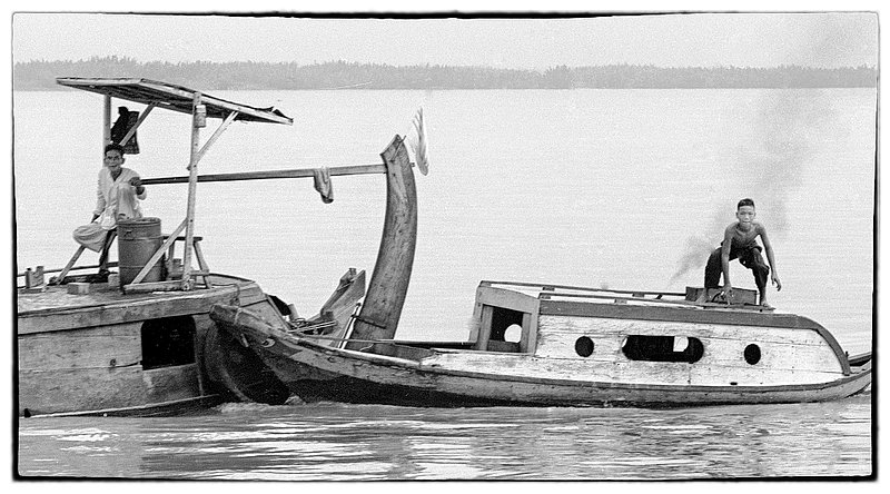 Viet watermen.jpg :: Vietnamese boats come in all sizes and shapes often times not only supplying commerce needs but also serving as homes.