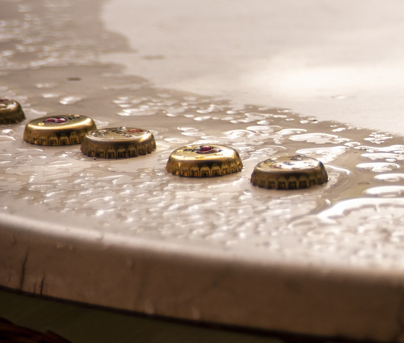 bottle caps on a wet table.jpg :: bottle caps on a wet table