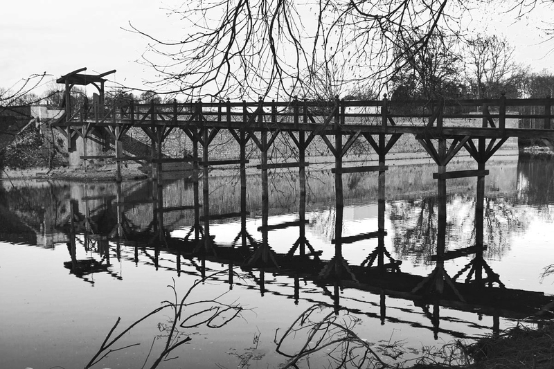 FRA_9852bw(1).jpg :: Wooden Drawbridge reflecting in moat at Château de Sully, France