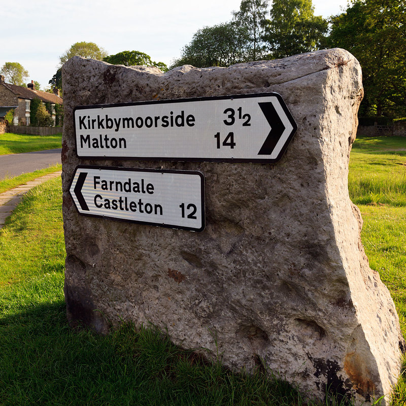 NYM19_003.jpg :: Direction signposts attached to rock in Hutton-le-Hole, North Yorkshire