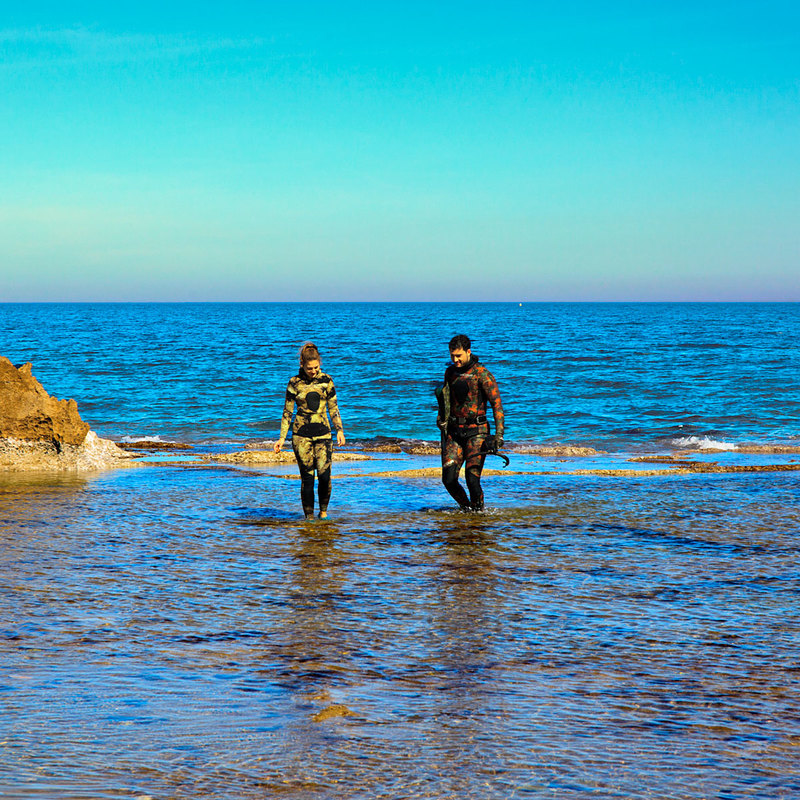 SPN19_414-1.jpg :: Surfers emerging from the sea at Los  Arenetes in the San Antnio Marine Reserve, Les Rotes, Denia, Spain