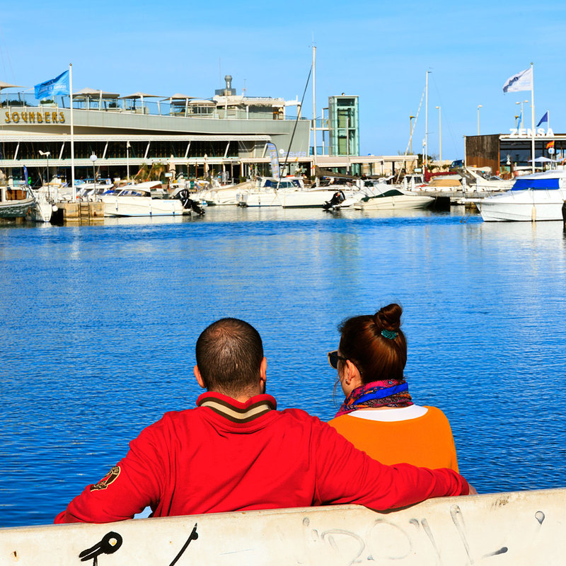 SPN19_452-1.jpg :: Couple relaxing by the water in Dénia Port in the Costa Blanca, Spain