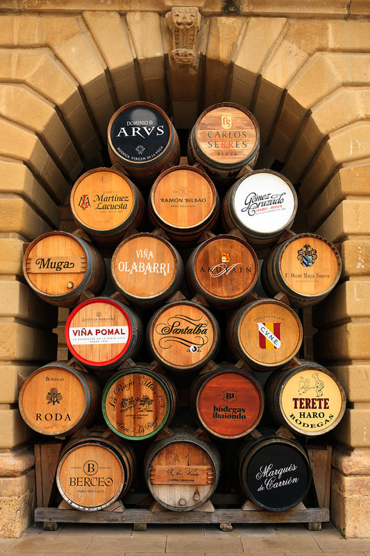 SPN19_539.jpg :: Wine barrels from the Rioja wine producers of the region displayed in the arches of the Town Hall in Haro, La Rioja, Spain