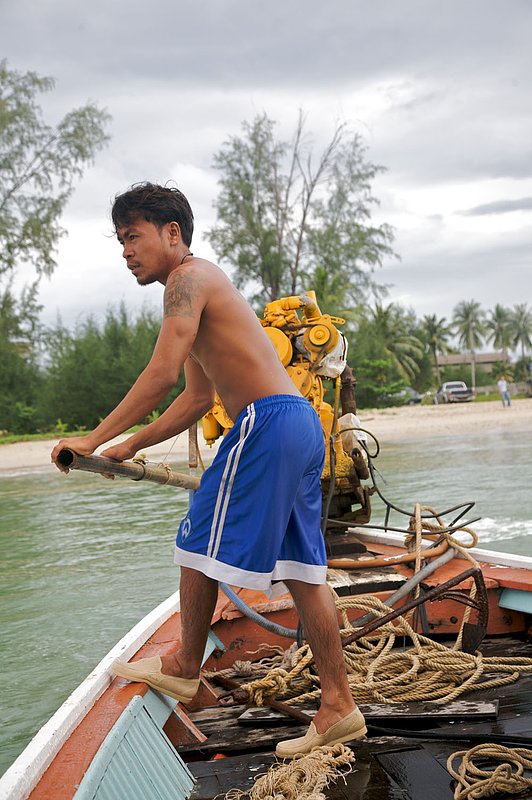 IMG_7911.jpg :: A Thai boat captain manning a longtail, Khao Lak, Thailand.
