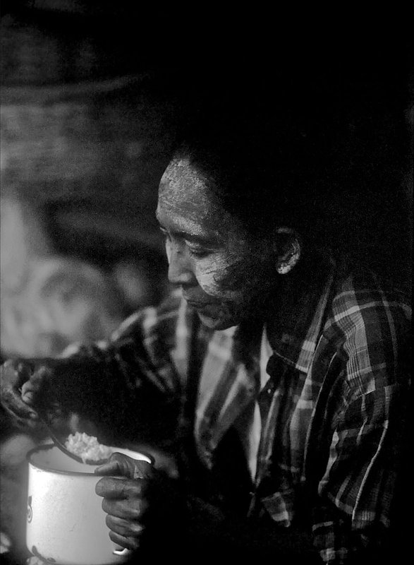 burmeseolderwoman.jpg :: A Burmese market worker takes a break to eat rice soup in Bagan, Myanmar.