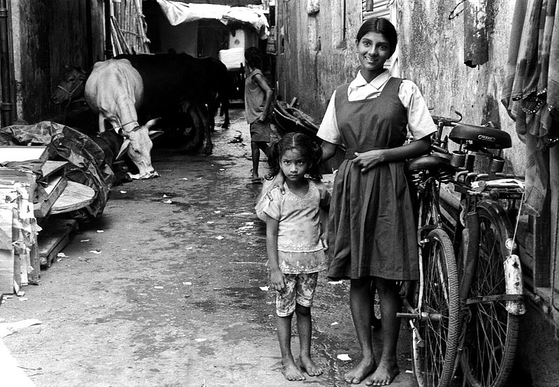cowalley2.jpg :: Indian sisters next to their home in Mumbai, India.