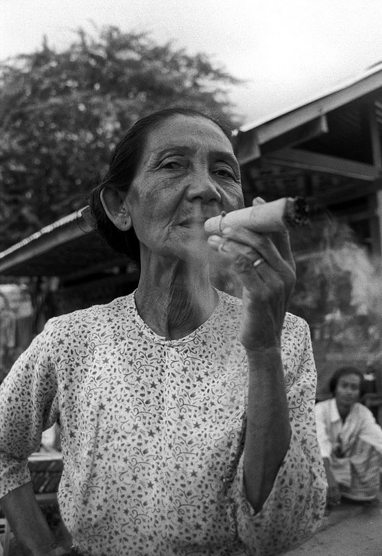 nostralsmoke.jpg :: An elderly Burmese woman smoking a cigar that she just rolled in Bagan, Myanmar.