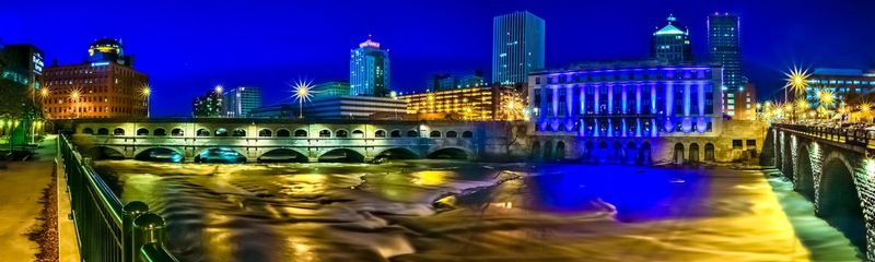 NY468at14x48.jpg :: Panoramic view of the Aqueduct area along the Genesee River with the Rundle Library decked out in blue

Rochester NY - Fall 2015